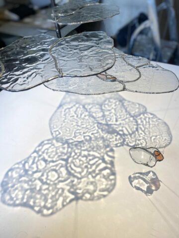 Nacelle, verres thermoformés, vitrail au cuivre, 90 x 90 x 250cm, 2025, © Sculpture, Verre, Vitrail, Installation, Matières, Existentialisme écologique, Projections, Textures, Surface, Profondeur, Transparence, Lumière, Perception, Sensation, Réel, Morphogenèse, Eau, Naissance, Toulouse, Occitanie